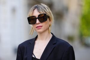 PARIS, FRANCE - MAY 08: Emy Venturini wears black sunglasses from Courreges, a black oversized blazer jacket from Prada, a black V-neck short dress from Zara, during a street style fashion photo session, on May 08, 2022 in Paris, France. (Photo by Edward Berthelot/Getty Images)