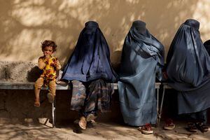 Una niña sentada con mujeres que usan burka afuera de un hospital en Kabul, Afganistán. Foto REUTERS / Jorge Silva.
