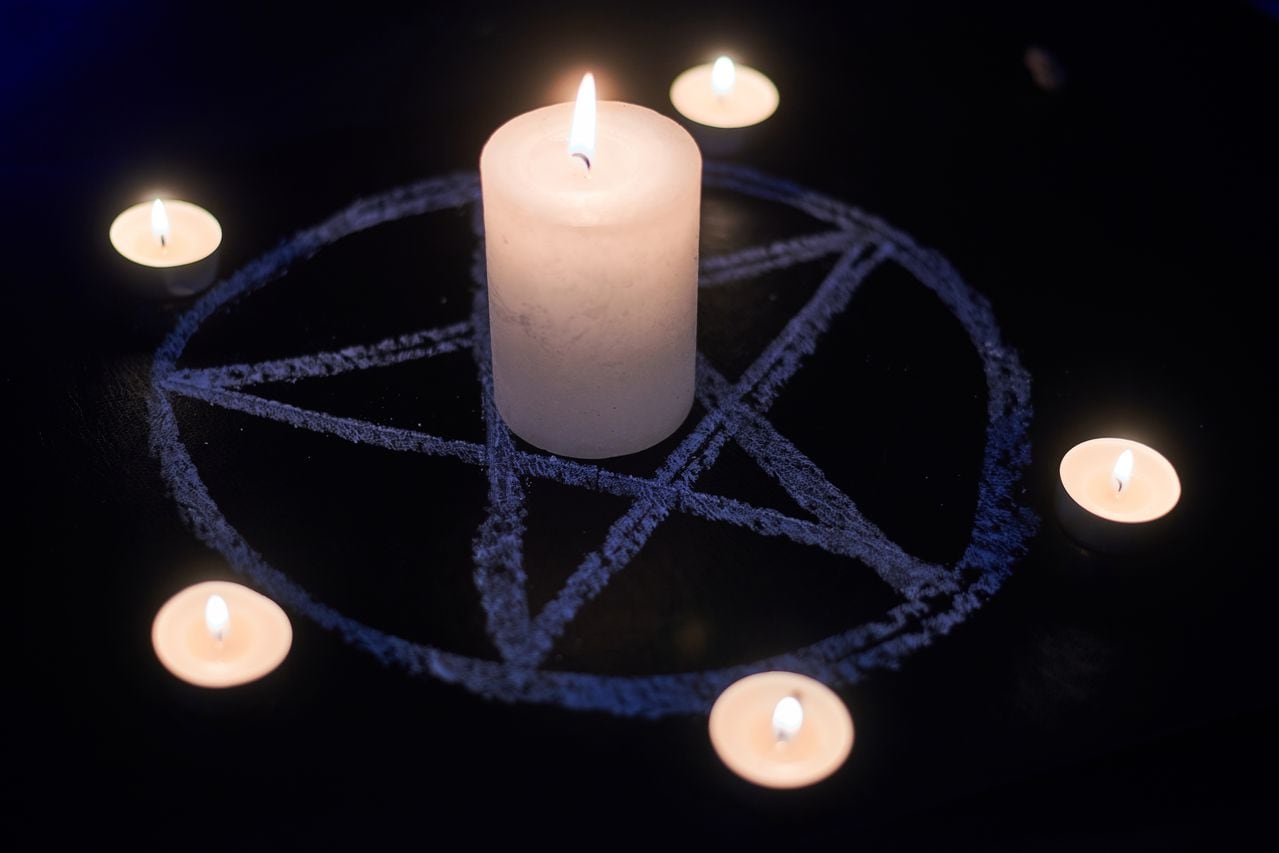 Pentagram and burning candles. The magical ritual of Satanism, invocation of spirits, spiritualistic sessions.