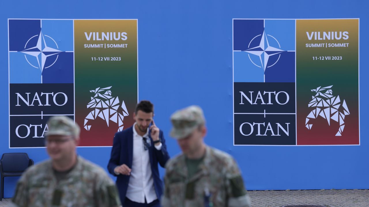 Los soldados pasan junto a un cartel en el lugar de la cumbre de la OTAN el 9 de julio de 2023 en Vilnius, Lituania