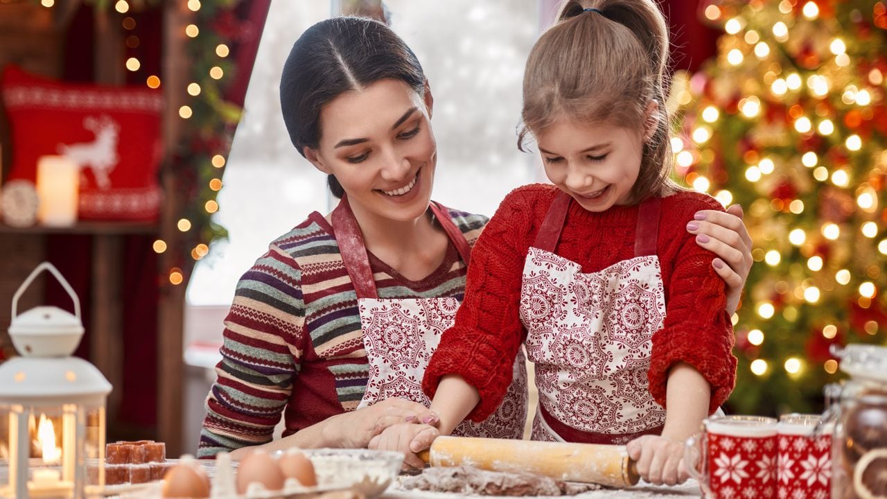 Feliz Navidad y Felices Fiestas. Comida de vacaciones de preparación familiar. Madre e hija cocinando galletas de Navidad.