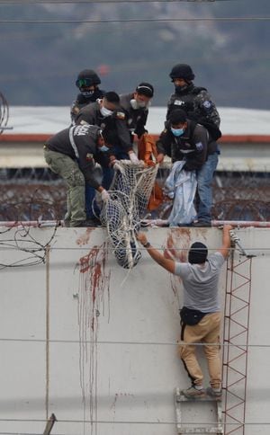 Grupo de rescate intentan bajar el cuerpo de uno de los muertos en la masacre en la cárcel de Ecuador