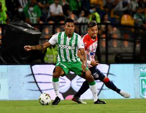 Alexander Mejía y Fernando Uribe disputan el balón en un partido entre Nacional y Junior por la fecha 2 de la Liga Betplay 2022-I