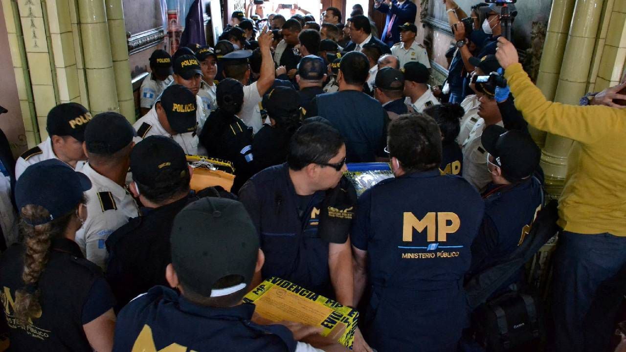 Fiscales del Ministerio Público (MP) de Guatemala cargan cajas con actas de las elecciones presidenciales durante un allanamiento.