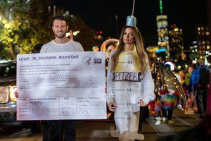 Personas disfrazadas de vacuna y tarjeta de vacunación participan en el Desfile de Halloween de Nueva York cuando el evento regresa a las calles del Bajo Manhattan por primera vez desde el brote de la enfermedad por coronavirus (COVID-19) en la ciudad de Nueva York, Nueva York, EE. UU., 31 de octubre , 2021. Foto REUTERS / Eduardo Muñoz