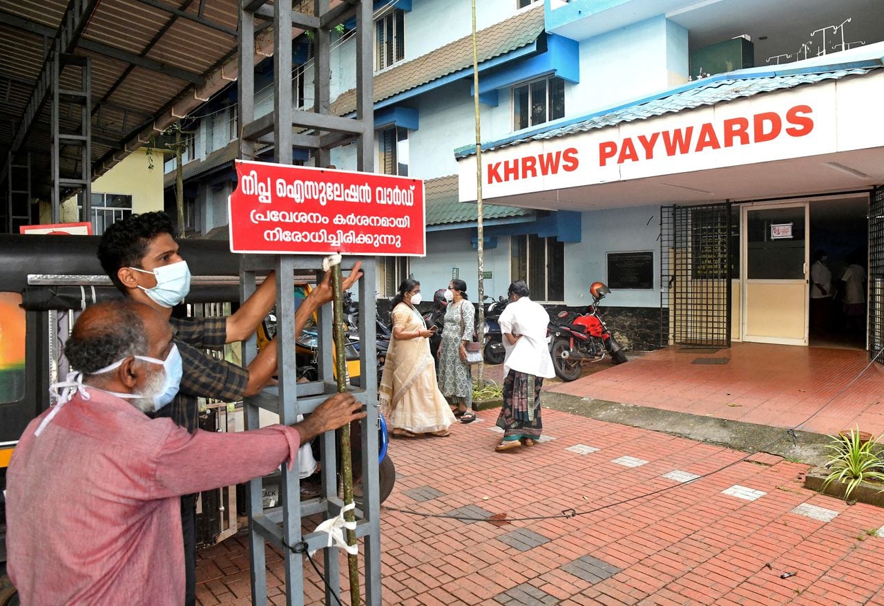Miembros del personal instalan un cartel que dice "Sala de aislamiento de Nipah, entrada estrictamente prohibida" en un hospital donde se está preparando una sala para pacientes sospechosos de virus Nipah en el distrito de Kozhikode, Kerala, India, el 12 de septiembre de 2023.