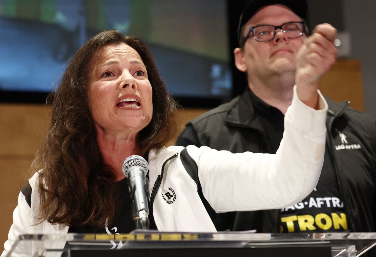 LOS ANGELES, CALIFORNIA - JULY 13: SAG-AFTRA President Fran Drescher speaks as SAG-AFTRA National Executive Director Duncan Crabtree-Ireland looks on at a press conference announcing their strike against Hollywood studios on July 13, 2023 in Los Angeles, California. Members of SAG-AFTRA, Hollywood�s largest union which represents actors and other media professionals, will join striking WGA (Writers Guild of America) workers at midnight in the first joint walkout against the studios since 1960. The strike could shut down Hollywood productions completely with writers in the third month of their strike against the Hollywood studios.   Mario Tama/Getty Images/AFP (Photo by MARIO TAMA / GETTY IMAGES NORTH AMERICA / Getty Images via AFP)