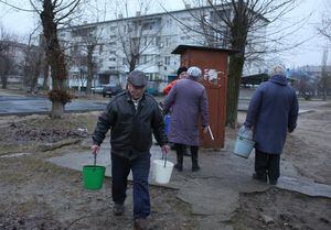 Residentes recogen agua en Schastia, en la ciudad ucraniana de Lugansk, el 23 de febrero de 2022 (Photo by Anatolii Stepanov / AFP)