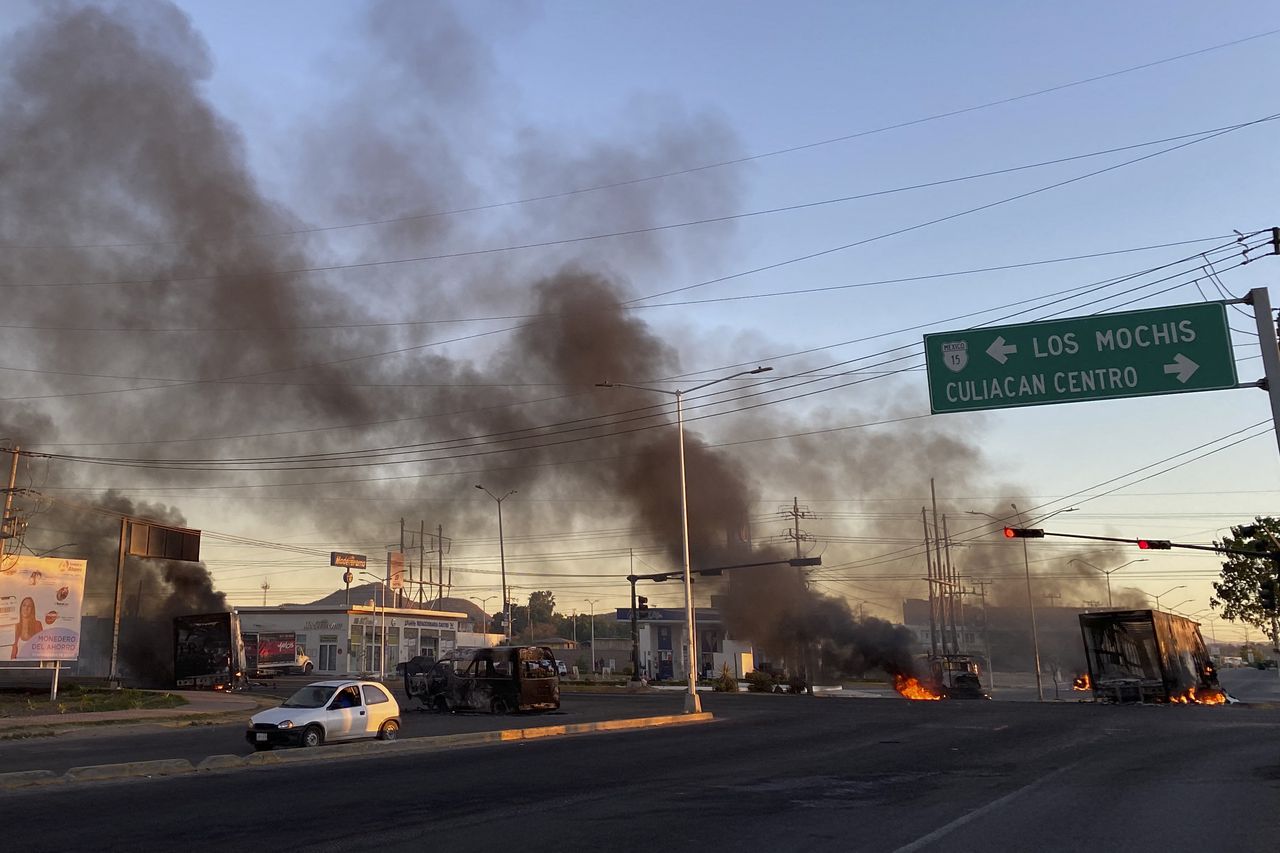 Burning vehicles are seen across the street during an operation to arrest Joaquin's son "El Chapo" Guzmán, Ovidio Guzmán, in Culiacán, Sinaloa state, Mexico, on January 5, 2023. - Intense gunfire rocked the heart of a cartel in northwestern Mexico on Thursday after security forces launched an operation in which allegedly arrested a son of jailed drug lord Joaquín "El Chapo" Guzman.  (Photo by Marcos Vizcarra / AFP)