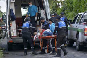 A wounded inmate is transported from a truck to an ambulance after a riot, outside the Bella Vista prison in Santo Domingo de los Tsachilas, Ecuador, on May 9, 2022. - At least two inmates were killed and five wounded in a riot at a prison in central Ecuador, Interior Minister Patricio Carrillo informed on Monday. (Photo by Juan Carlos PEREZ / AFP)