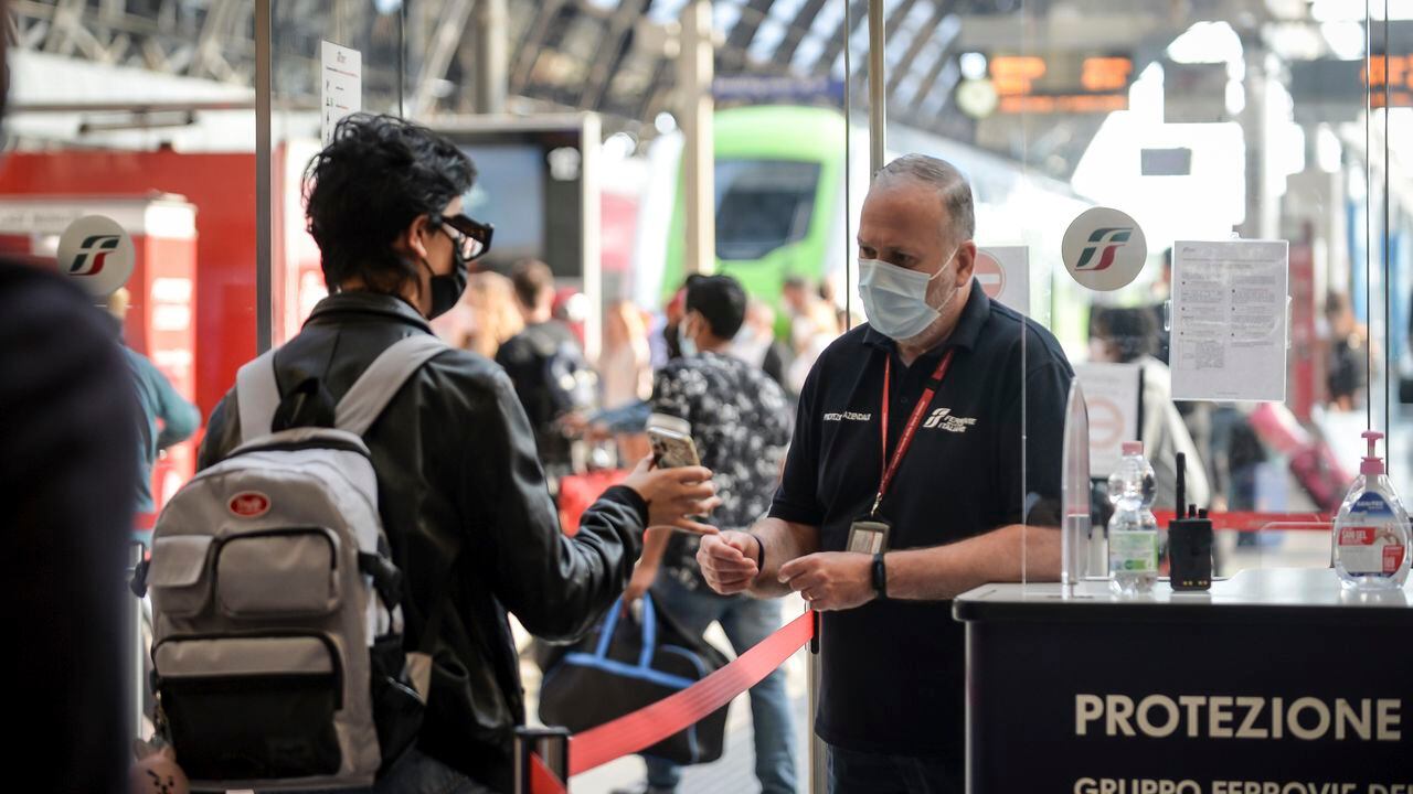 Un pasajero sostiene su teléfono en un punto de control en la estación de tren Stazione Centrale de Milán, Italia. (Claudio Furlan / LaPresse vía AP)
