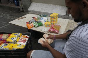 Un hombre cuenta billetes en Caracas, Venezuela. (AP Foto/Ariana Cubillos)