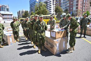 Military personnel prepare to dispatch election material during preparations on the eve of the local elections and referendum in Quito on February 4, 2023. - Some 13.4 million Ecuadorians will go to the polls this Sunday to elect 23 provincial prefects, 221 mayors, 1,307 councilors, and other subnational authorities. The referendum vote will rule on constitutional reforms which include the extradition of compatriots, the reduction of the number of national legislators, and a change in regulations related to natural resources among others. (Photo by Rodrigo BUENDIA / AFP)