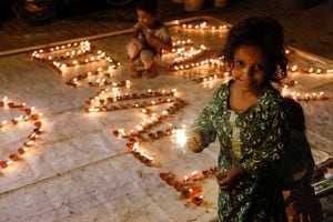 Una niña agita una bengala en llamas durante Diwali, el festival hindú de las luces, en Karachi, Pakistán, el 24 de octubre de 2022. 