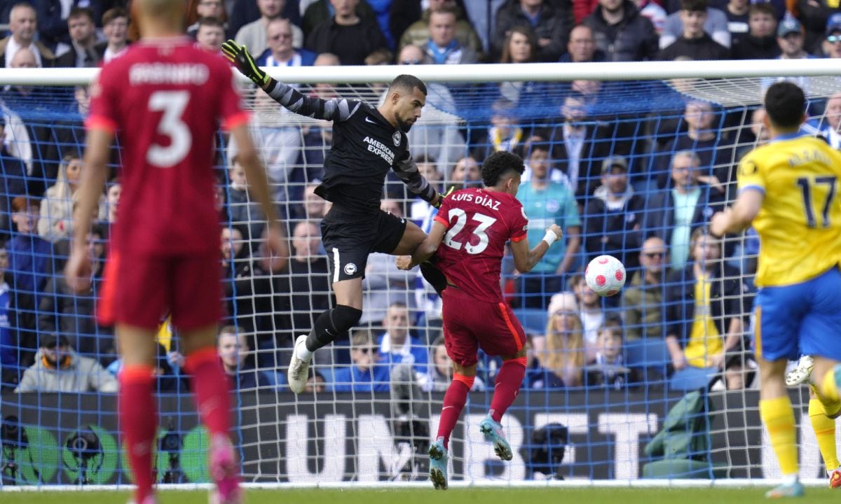 Liverpool's Luis Diaz, right, scores his side's first goal as Brighton's goalkeeper Robert Sanchez jumps during the English Premier League soccer match between Brighton and Hove Albion and Liverpool at the Amex stadium in Brighton, England, Saturday, March 12, 2022. (AP/Kirsty Wigglesworth)