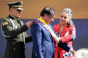La senadora colombiana María José Pizarro (D) pone la faja presidencial al nuevo presidente de Colombia Gustavo Petro (C) durante la ceremonia de toma de posesión en la plaza de Bolívar en Bogotá, el 7 de agosto de 2022.