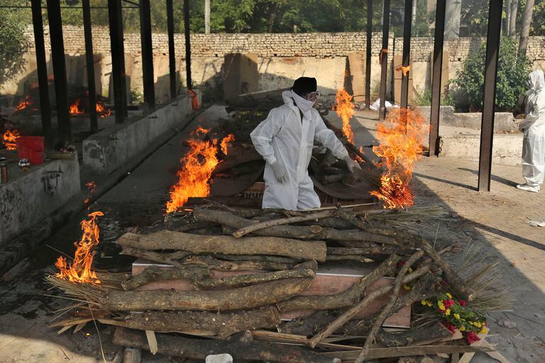Un familiar de una persona fallecida por el coronavirus, a quien están incinerando, en Jammu, India. (AP Foto/Channi Anand)