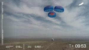 En esta imagen del video puesto a disposición por Blue Origin, la cápsula New Shepard usa paracaídas para aterrizar durante una prueba en el oeste de Texas el miércoles, April 14, 2021. (Blue Origin via AP)