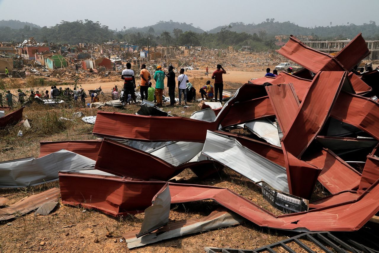La gente observa los daños causados cuando un vehículo que transportaba explosivos mineros detonó a lo largo de una carretera en Apiate, Ghana. Foto REUTERS/Francis Kokoroko
