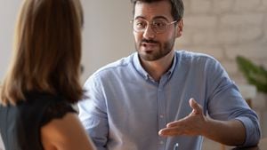 El candidato masculino caucásico responde a las preguntas de la gerente de recursos humanos durante una entrevista de trabajo en el cargo. Proceso de reunión, comunicaciones de negociaciones entre partes comerciales, soluciones y concepto de opinión.