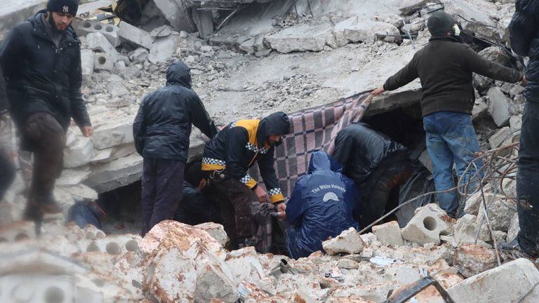 Los rescatistas buscan sobrevivientes bajo los escombros en Siria, luego de un terremoto.