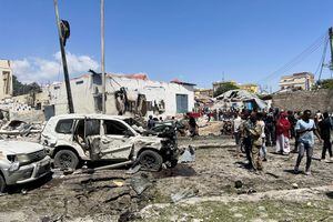 Las personas miran los vehículos destrozados en la escena de una explosión en el distrito Hamarweyne de Mogadiscio, Somalia, el 12 de enero de 2022. Foto REUTERS/Feisal Omar
