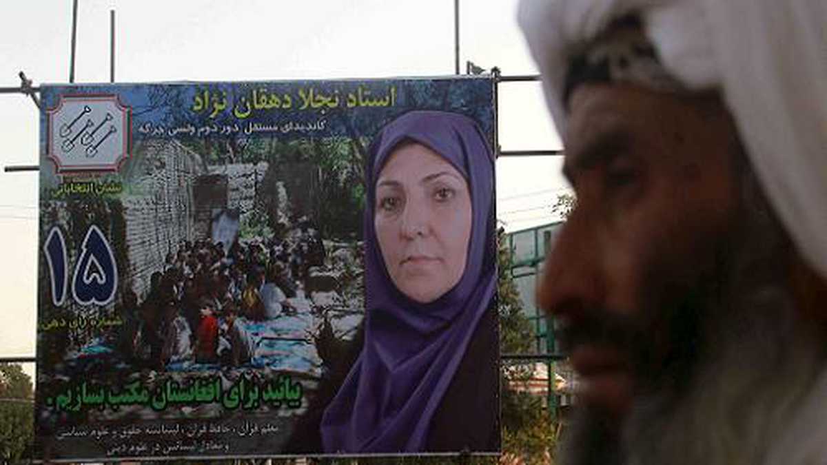 Un hombre camina junto a un cartel de la candidata al parlamento de Afganistán, Najla Dahqan, en Herat, Afganistán. Algunos carteles electorales de candidatas mujeres están siendo dañados por grupos afines a los talibanes. Las elecciones parlamentarias están previstas para el 18 de septiembre de 2010.