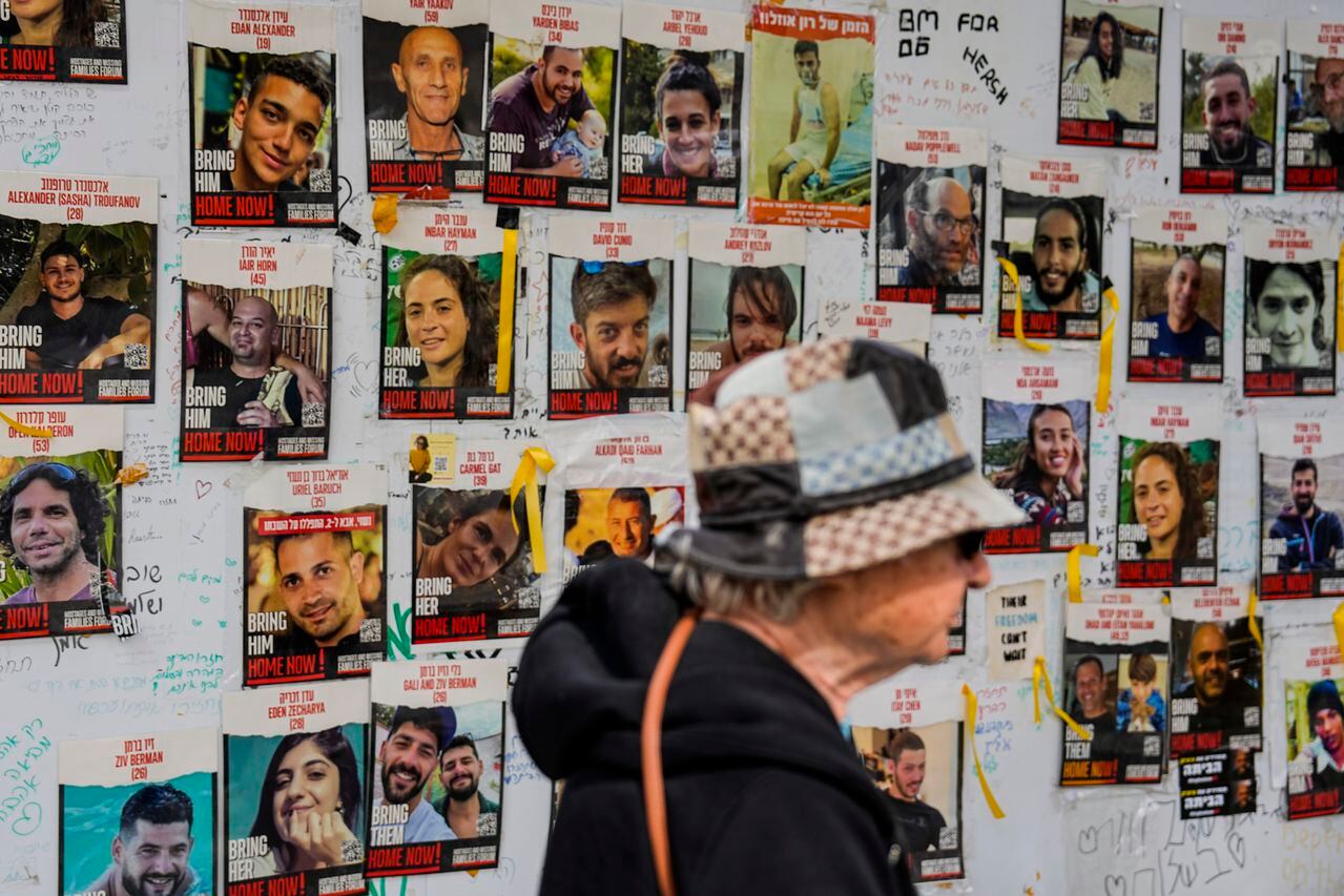 Una mujer pasa junto a fotografías de rehenes en Tel Aviv, Israel, el lunes 12 de febrero de 2024.