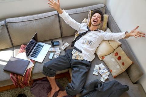 man bursting with joy with lots of money