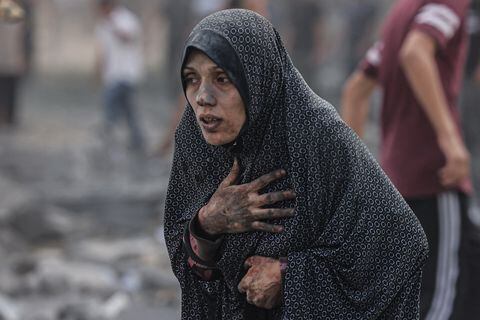 Una mujer palestina cubierta de polvo reacciona tras un ataque aéreo israelí contra edificios en Rafah, en el sur de la Franja de Gaza, en medio de las batallas en curso entre Israel y el grupo palestino Hamás.