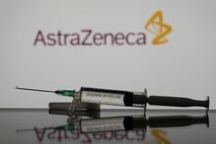 En esta ilustración fotográfica se ve una vacuna contra el covid-19 con el logo de AstraZeneca al fondo. (Ilustración fotográfica de Nikos Pekiaridis/NurPhoto vía Getty Images)
