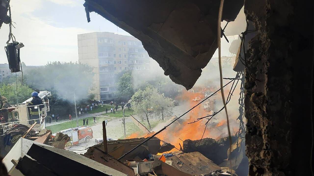 Servicios de emergencias trabajan en el lugar donde un misil golpeó un edificio de apartamentos en Ucrania.