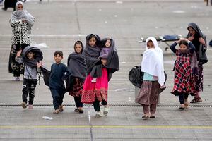 Los niños caminan en un área entre las carpas en la base aérea de Ramstein U.S. en Ramstein, Alemania, lunes, 30 de agosto de 2021. La comunidad militar estadounidense más grande en el extranjero alberga miles de evacuados afganos en una ciudad de TENT en la barra aérea. (AP Foto / Matthias Schrader)