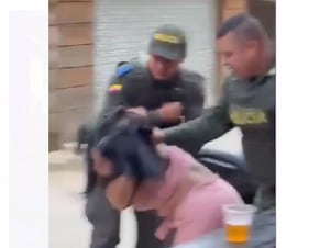 La mujer es sacada de un bar en Remedios por dos policías.