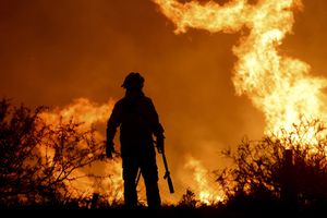 La silueta de un bombero junto a las llamas de un incendio forestal en las afueras de Villa Carlos Paz, Argentina, el martes 10 de octubre de 2023.