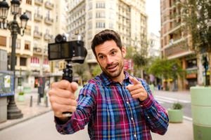 Streamer man records a video with a camera in a city