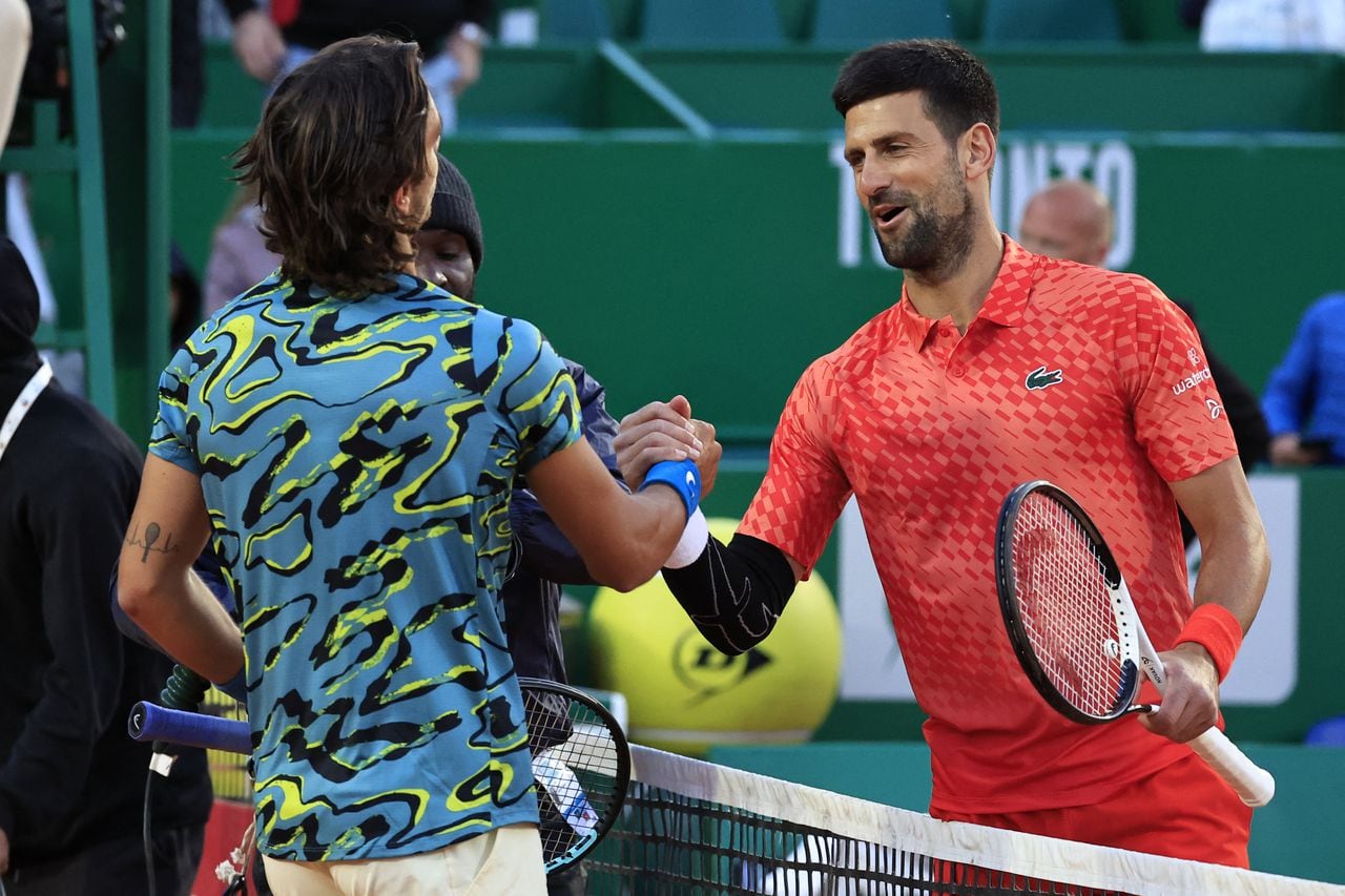 Serbia's Novak Djokovic (R) and Italy's Lorenzo Musetti (L) shake hands after their Monte-Carlo ATP Masters Series tournament round of 16 tennis match in Monte Carlo on April 13, 2023. (Photo by Valery HACHE / AFP)