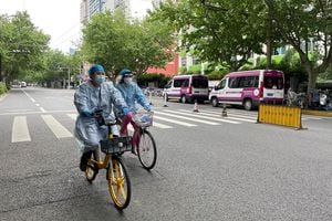 Trabajadores andan en bicicleta en una calle en medio de un brote de enfermedad por coronavirus (COVID-19), durante el feriado del Día del Trabajo en Shanghái, China, 30 de abril de 2022. Foto REUTERS/Brenda Goh