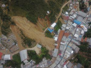 El alud de tierra sepultó por lo menos 60 casas.(Photo by Said VELASQUEZ / AFP)