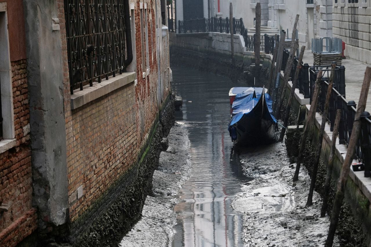 Una góndola se muestra en un canal durante una marea baja severa en la ciudad laguna de Venecia, Italia, 17 de febrero de 2023.