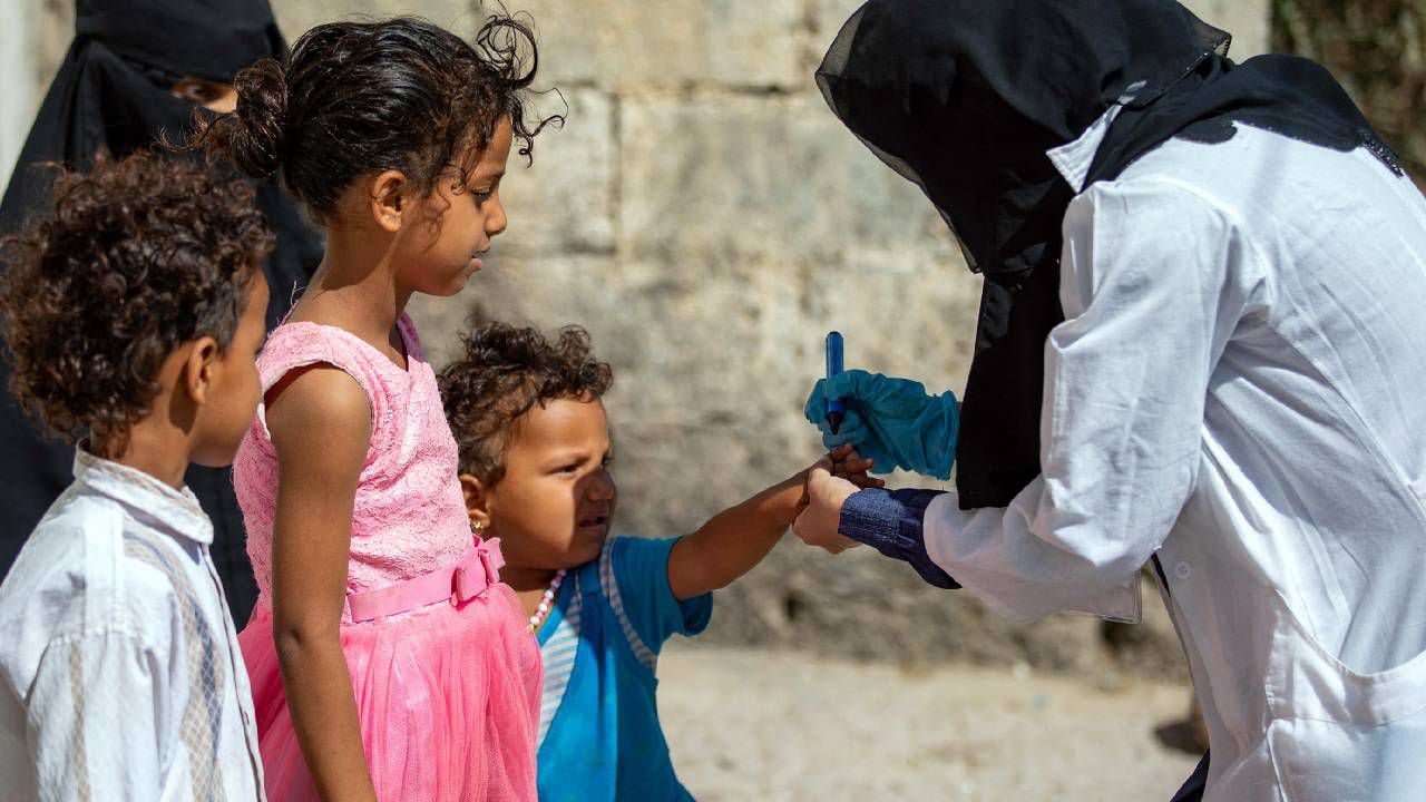 Un trabajador de la salud yemení marca a un niño con un marcador después de administrarle la vacuna contra la poliomielitis como parte de una campaña de inmunización.