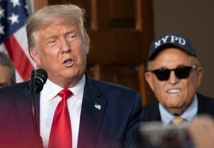 (FILES) In this file photo taken on August 14, 2020, Trump's personal lawyer Rudy Giuliani listens as US President Donald Trump delivers remarks to the City of New York Police Benevolent Association at the Trump National Golf Club in Bedminster, New Jersey.. - Former US president Donald Trump complained on April 29, 2021, that an April 28 FBI raid on the New York apartment of  Giuliani was "so unfair." (Photo by JIM WATSON / AFP)