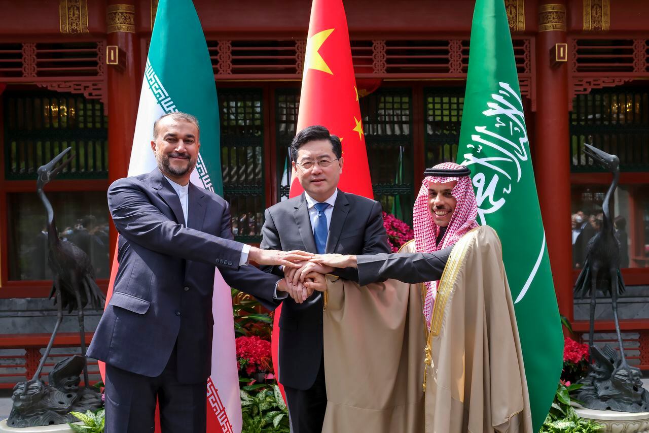 En esta foto de archivo publicada por la agencia de noticias Xinhua, el ministro de Relaciones Exteriores de Irán, Hossein Amirabdollahian, a la izquierda, se toma de la mano con su homólogo de Arabia Saudita, el príncipe Faisal bin Farhan Al Saud, a la derecha, y su homólogo chino, Qin Gang