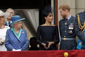 ARCHIVO - En esta foto de archivo del martes 10 de julio de 2018, la reina Isabel II de Gran Bretaña, Meghan la duquesa de Sussex y el príncipe Harry se paran en un balcón para ver pasar un avión de la Royal Air Force sobre el Palacio de Buckingham en Londres. El momento no podría ser peor para Harry y Meghan. El duque y la duquesa de Sussex finalmente tendrán la oportunidad de contar la historia detrás de su salida de los deberes reales directamente al público el domingo 7 de marzo de 2021, cuando se transmita su entrevista de dos horas con Oprah Winfrey. (Foto AP / Matt Dunham, archivo)