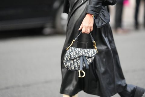 Una invitada lleva un vestido de cuero negro, un bolso Saddle con monograma azul y blanco de Dior, afuera de Viktor & Rolf, durante la Alta Costura Primavera/Verano 2024 como parte de la Semana de la Moda de París el 24 de enero de 2024 en París, Francia
