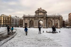 La gente camina a través de la nieve en la plaza Puerta de Alcalá en el centro de Madrid, España, el domingo 10 de enero de 2021. Una gran parte del centro de España, incluida la capital de Madrid, está limpiando lentamente la nieve después de la peor tormenta de nieve que se recuerde en el país. Foto AP / Manu Fernandez
