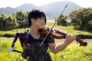 In this photo taken on August 28, 2021, Japanese musician Manami Ito, who is also a qualified nurse and former Paralympic swimmer, plays the violin using her prosthetic arm during a photography session in Shizuoka. - The Japanese musician enthralled a nation with her brief but showstealing performance at the opening ceremony of the Tokyo Paralympics, and playing violin isn't even her day job. (Photo by Yuki IWAMURA / AFP) / TO GO WITH PARALYMPICS-2020-2021-JAPAN-MUSIC-DISABLED,INTERVIEW BY ETIENNE PALMER AND HARUMI OZAWA