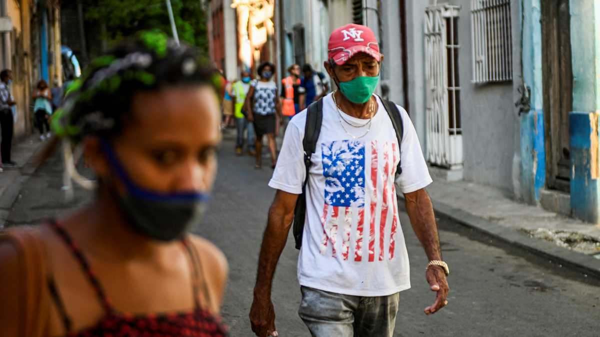 A man wearing a T-shirt with the US flag walks along a street of Havana, on May 17, 2022. - The United States said Monday it is easing restrictions imposed during former president Donald Trump's administration on travel to Cuba and on the sending of family remittances between the United States and the communist island. (Photo by YAMIL LAGE / AFP)