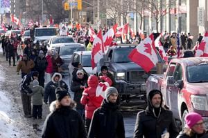 Camiones y simpatizantes viajan por Bloor Street durante una manifestación en apoyo de un convoy de camioneros en Ottawa que protesta por las restricciones de COVID-19, en Toronto,. Foto  AP/Nathan Denette/The Canadian Press