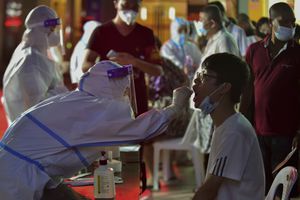 En esta foto publicada por la Agencia de Noticias Xinhua, un trabajador de la salud toma una muestra de hisopo de un residente durante una prueba masiva de COVID-19 en Putian, en la provincia de Fujian, en el sureste de China, el domingo 2 de septiembre. (Wei Peiquan/Xinhua via AP)